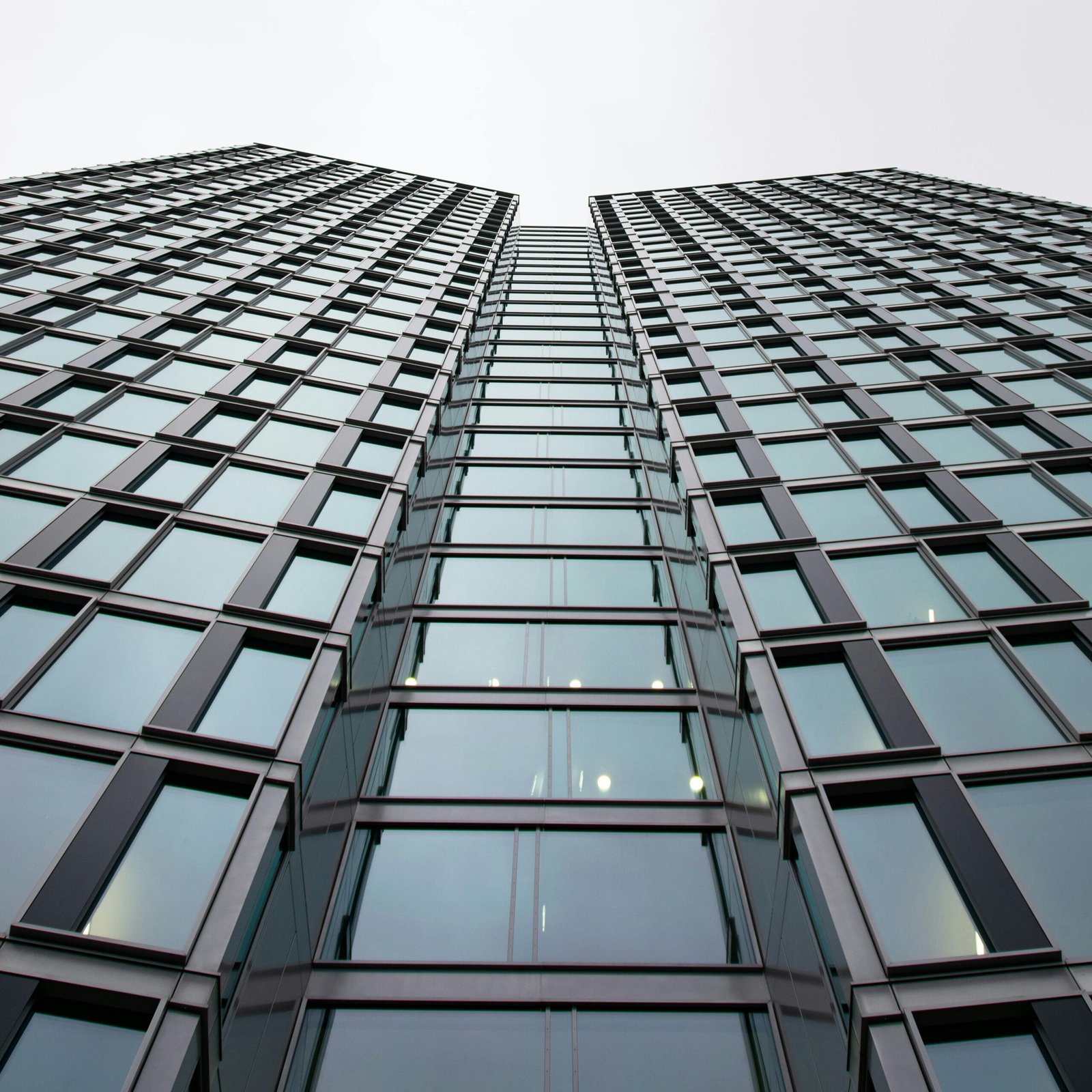 A compelling view of a modern skyscraper, emphasizing its sleek glass facade and vertical lines.